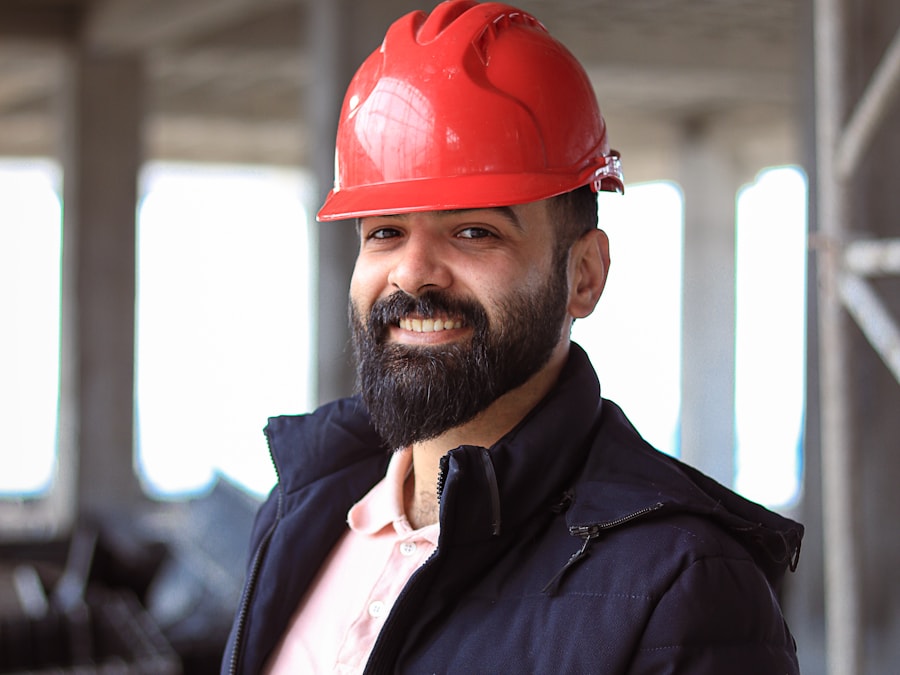 Smiling construction professional in a red hard hat looking at the camera